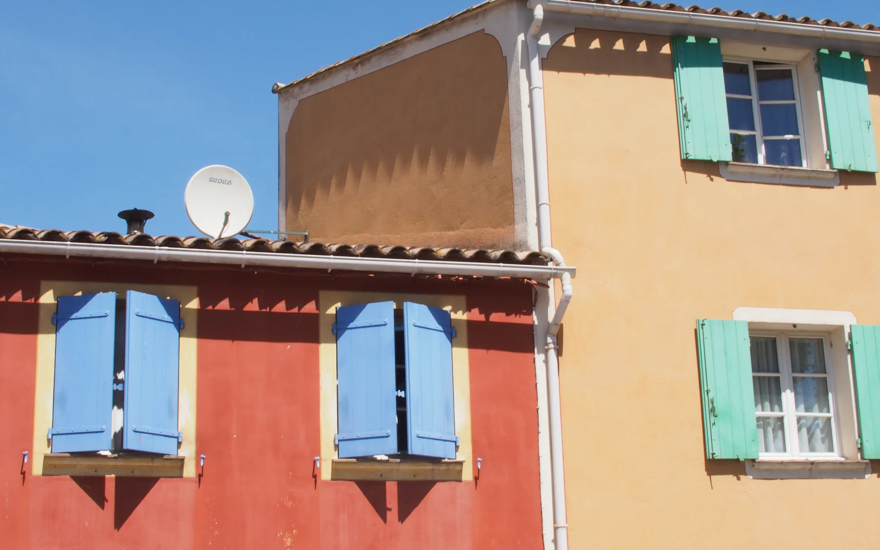 Façades provençales colorées aux volets bleus et verts, à Cogolin